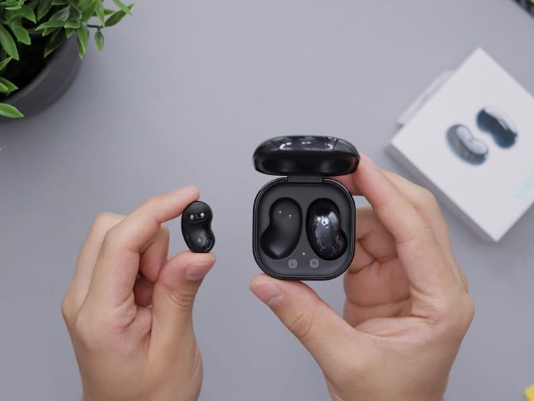 hands holding headphones and headphone charger box